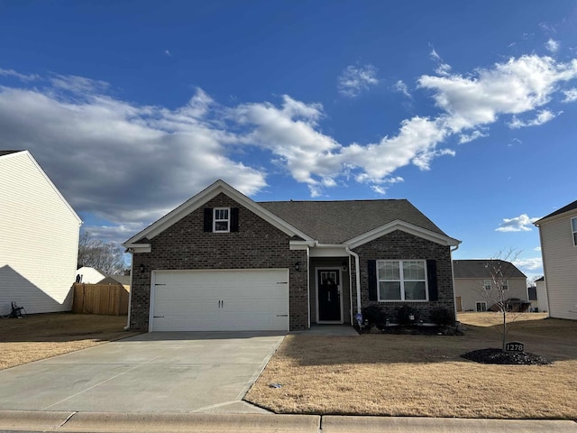 view of front facade featuring a garage, driveway, brick siding, and fence