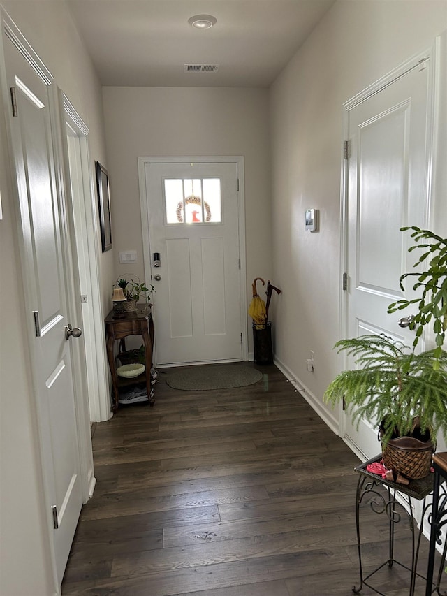 foyer with dark wood-style flooring, visible vents, and baseboards