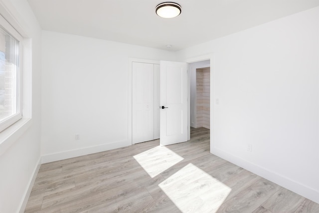 unfurnished room with light wood-style floors and baseboards