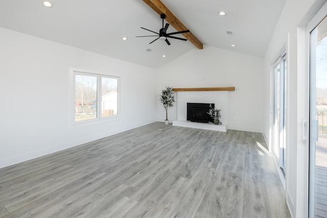 unfurnished living room featuring recessed lighting, light wood-style flooring, lofted ceiling with beams, a brick fireplace, and baseboards