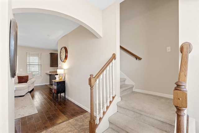 staircase featuring baseboards and wood finished floors