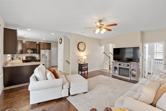 living area with recessed lighting, dark wood-style flooring, a ceiling fan, baseboards, and stairway