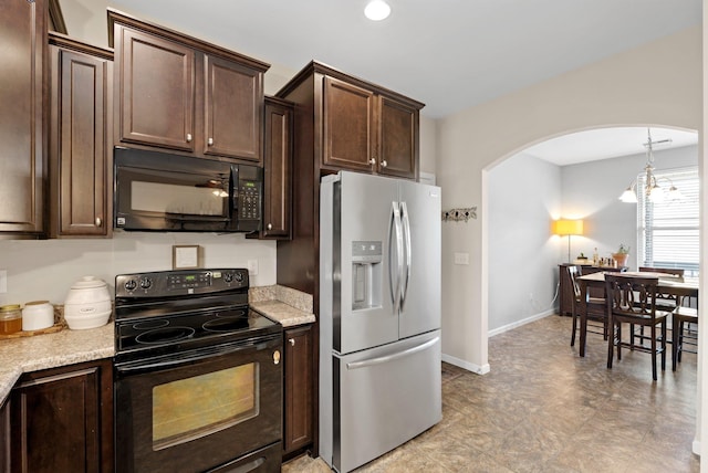 kitchen with arched walkways, an inviting chandelier, black appliances, dark brown cabinets, and baseboards