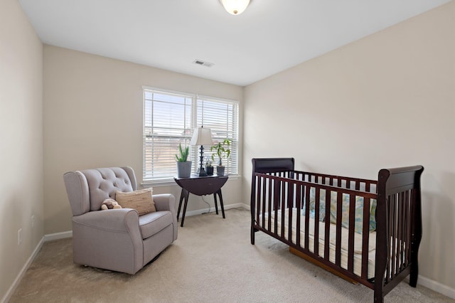 carpeted bedroom with a nursery area, visible vents, and baseboards