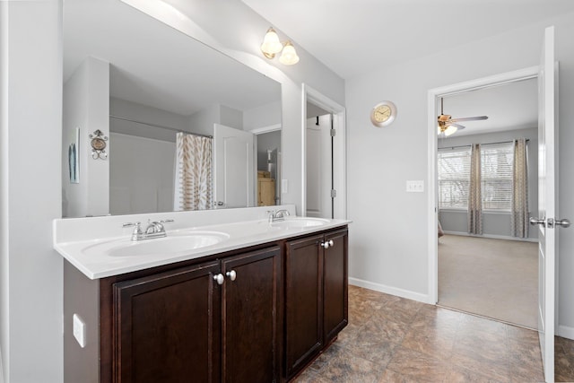 bathroom with double vanity, baseboards, and a sink