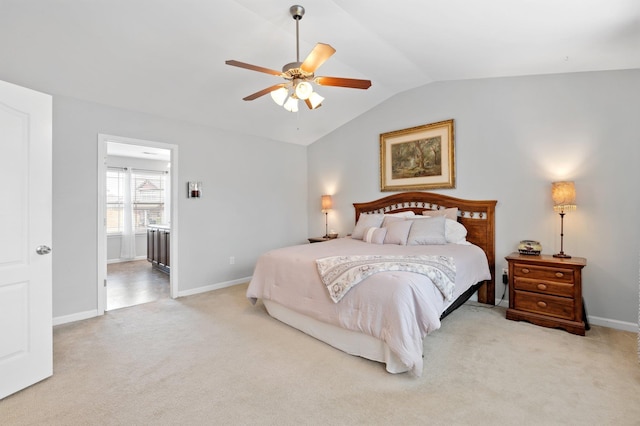 carpeted bedroom featuring lofted ceiling, ensuite bath, baseboards, and a ceiling fan