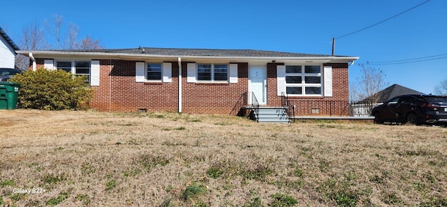 view of front facade with brick siding and a front yard