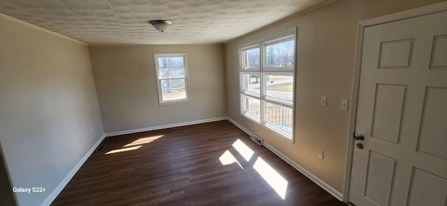 unfurnished room featuring crown molding, dark wood finished floors, visible vents, and baseboards