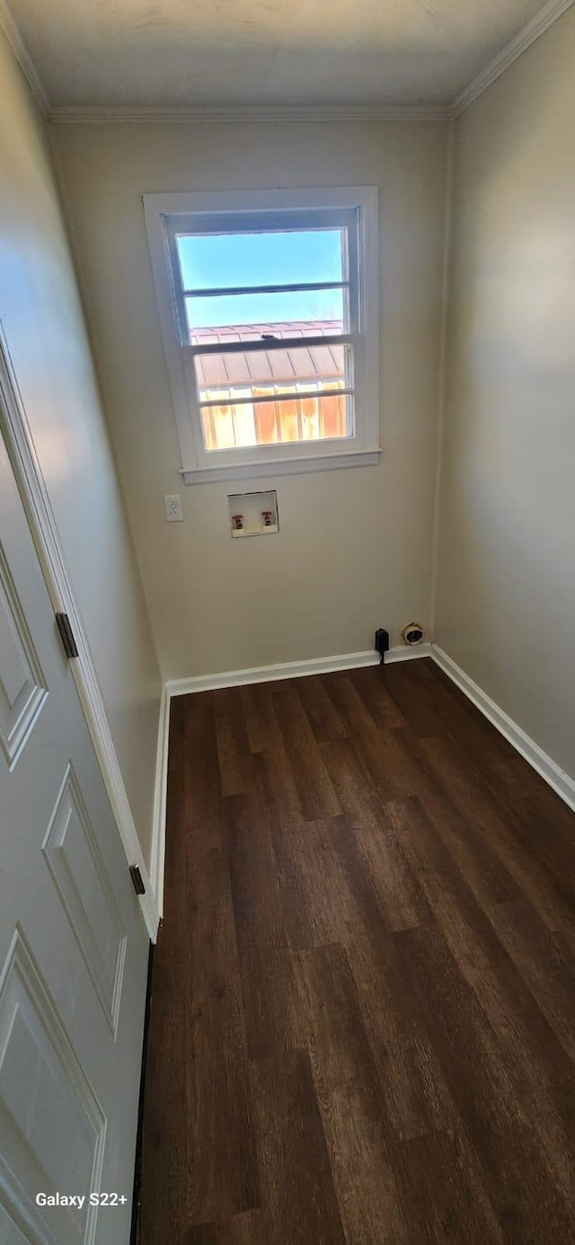 spare room featuring baseboards, dark wood finished floors, and crown molding