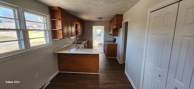 kitchen featuring light countertops, black / electric stove, a sink, and baseboards