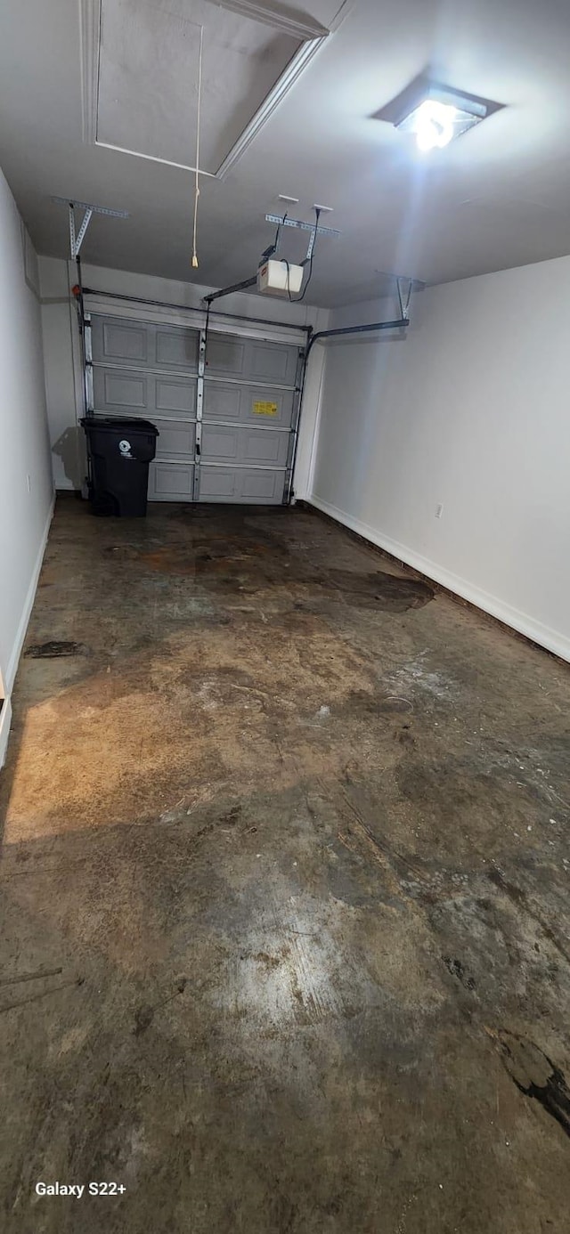 garage with baseboards and a garage door opener