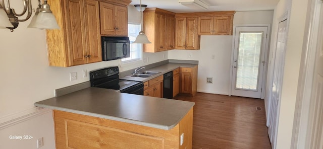 kitchen featuring black appliances, brown cabinets, and a sink