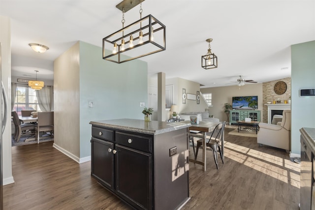 kitchen with a fireplace, dark wood-type flooring, and decorative light fixtures