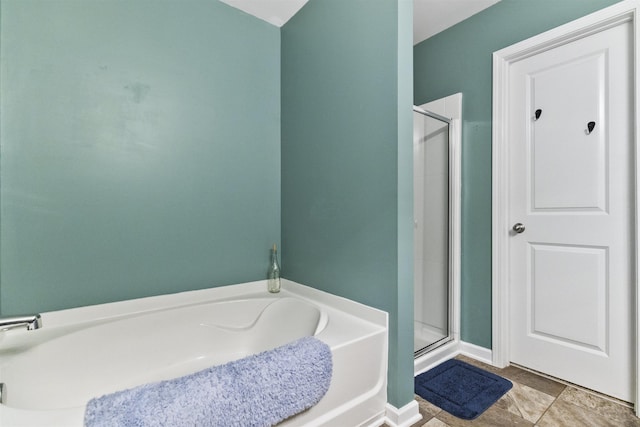 bathroom with a stall shower and a garden tub