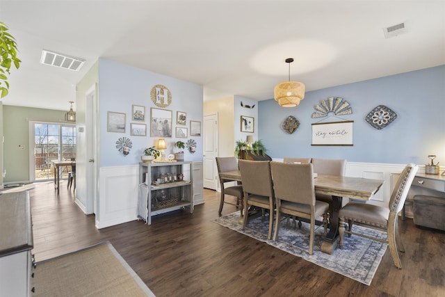 dining room featuring dark wood-style floors, wainscoting, and visible vents