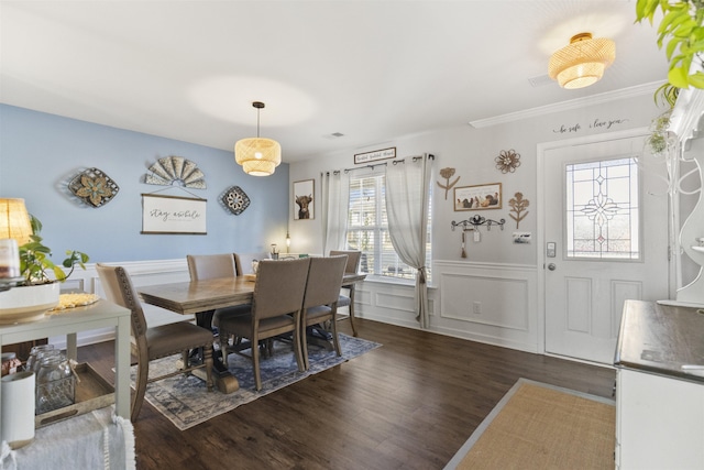 dining area featuring a wainscoted wall and dark wood finished floors