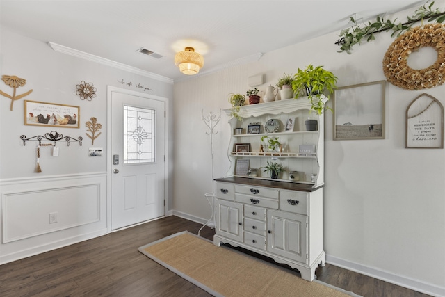 foyer entrance with dark wood-style flooring, visible vents, crown molding, and wainscoting