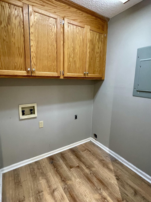 clothes washing area with cabinet space, electric panel, dark wood finished floors, hookup for an electric dryer, and washer hookup