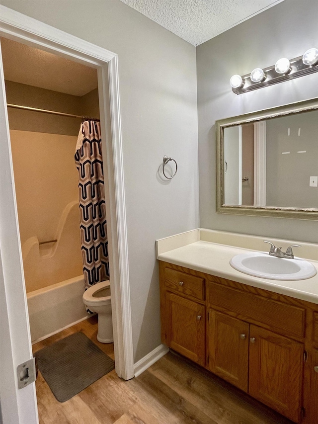 bathroom featuring shower / bathtub combination with curtain, toilet, vanity, a textured ceiling, and wood finished floors