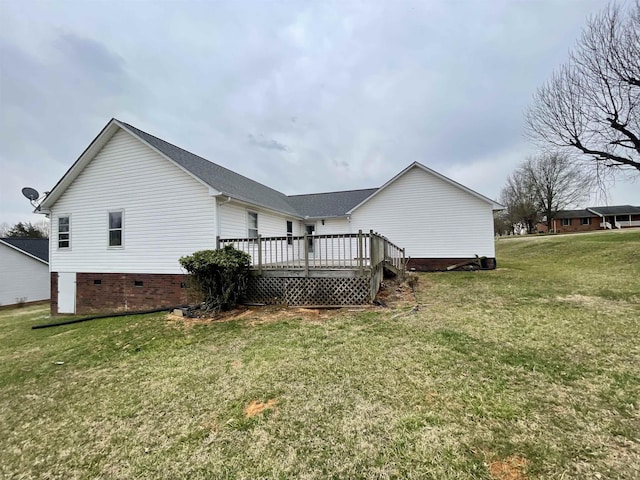 rear view of house featuring crawl space, a wooden deck, and a yard