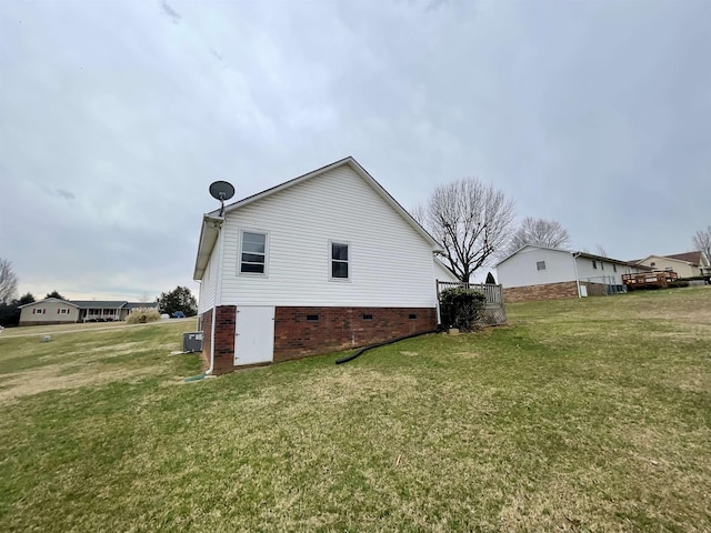 view of side of home featuring a yard, central AC unit, and crawl space