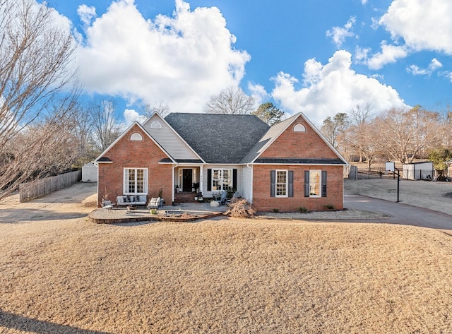 traditional home featuring brick siding and fence