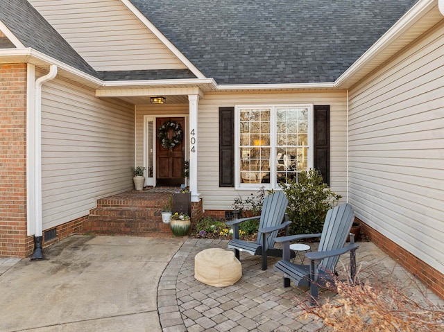 property entrance with a shingled roof, crawl space, and a patio area