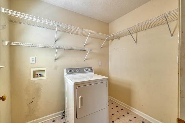 clothes washing area with a textured ceiling, laundry area, baseboards, tile patterned floors, and washer / dryer