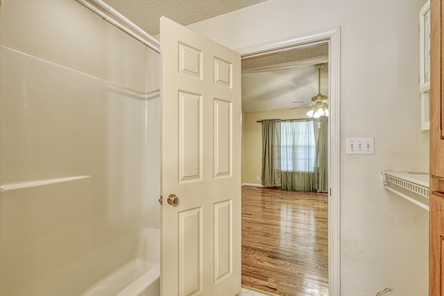 interior space with a textured ceiling and wood finished floors