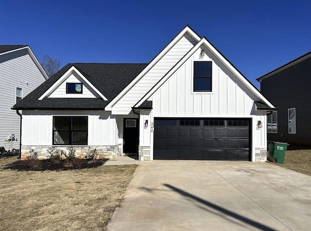 modern inspired farmhouse with stone siding, roof with shingles, board and batten siding, and driveway