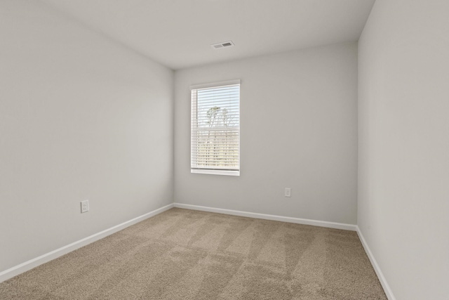 empty room with baseboards, visible vents, and carpet flooring