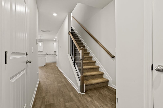 stairs with baseboards, wood finished floors, visible vents, and recessed lighting