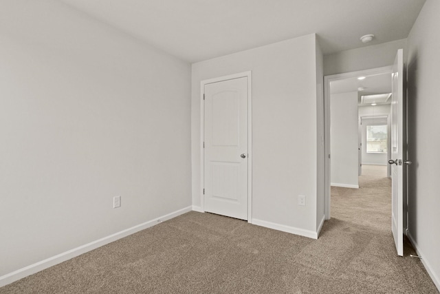 unfurnished bedroom featuring carpet floors and baseboards