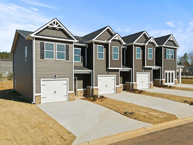 craftsman inspired home with an attached garage, stone siding, board and batten siding, and concrete driveway