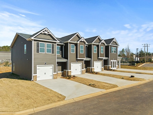 view of front of house featuring board and batten siding, stone siding, concrete driveway, and a garage