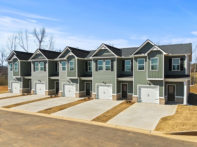 multi unit property with a garage, driveway, brick siding, and board and batten siding