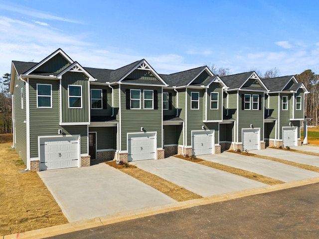 multi unit property with driveway, an attached garage, board and batten siding, and brick siding