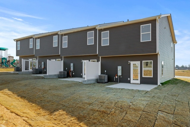 rear view of house featuring a playground, a patio, and central AC unit