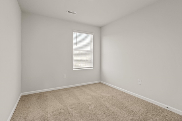 carpeted spare room with visible vents and baseboards