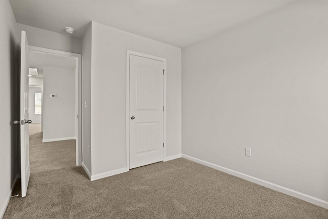 unfurnished bedroom featuring carpet flooring and baseboards