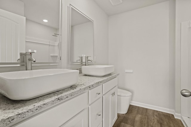 full bath featuring toilet, baseboards, a sink, and wood finished floors