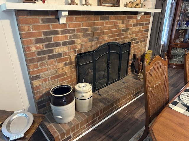 interior details with a brick fireplace and wood finished floors