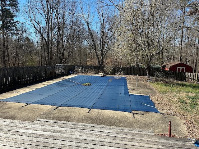 view of pool with a fenced in pool, a patio area, a shed, a fenced backyard, and an outdoor structure