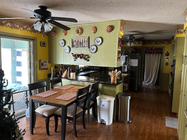 dining room with a textured ceiling, a ceiling fan, and dark wood-type flooring