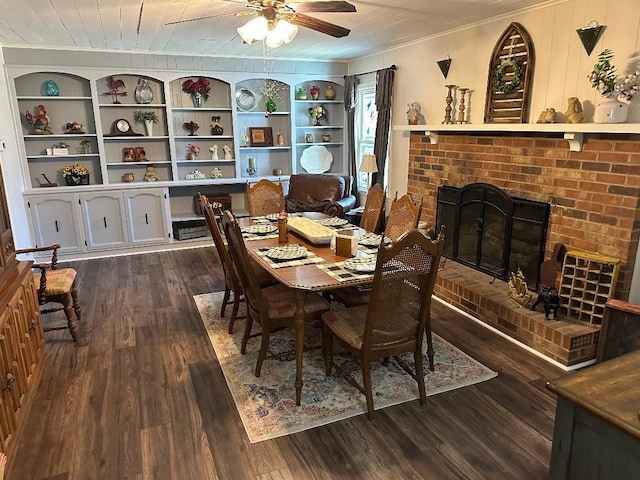 dining space featuring dark wood-type flooring, a fireplace, a ceiling fan, built in features, and ornamental molding