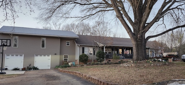 view of front of house with a garage, driveway, and a porch