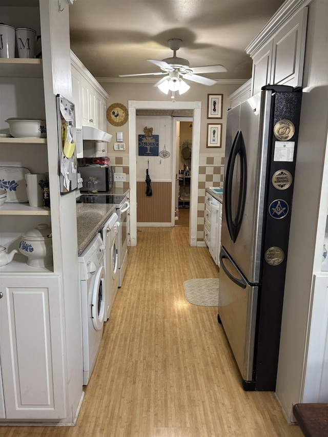 kitchen with washer / dryer, freestanding refrigerator, light wood-type flooring, under cabinet range hood, and white cabinetry