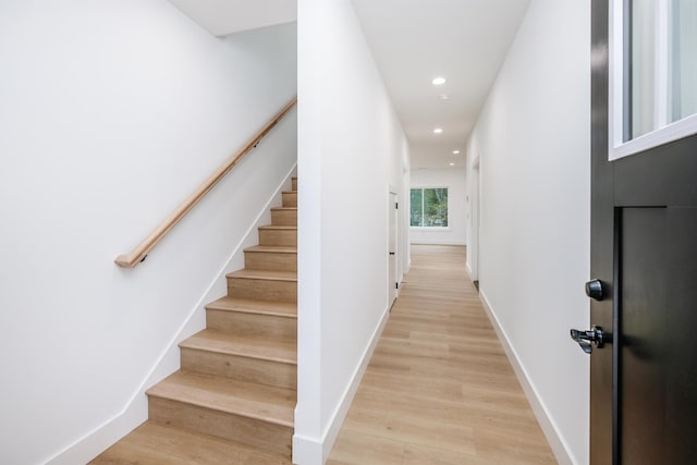 interior space with recessed lighting, baseboards, light wood finished floors, and stairs