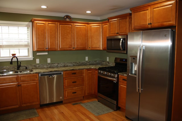 kitchen featuring appliances with stainless steel finishes, brown cabinets, and a sink