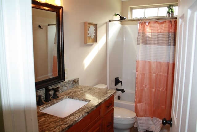 full bath with shower / tub combo with curtain, vanity, and toilet